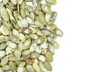 Close-up background texture of green pumpkin seeds on a white background. Space for text.