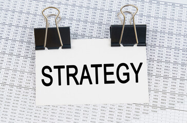 On the table there are reports and a business card with the inscription - STRATEGY