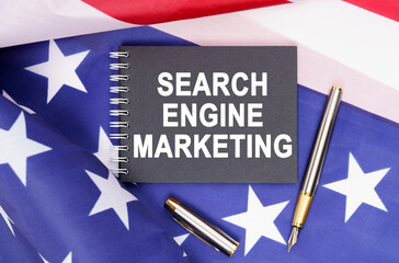 On the table is an American flag, a pen and a notebook with the inscription - SEARCH ENGINE MARKETING