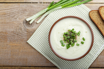 cauliflower cream soup on a table in a clay plate. nearby are spices.