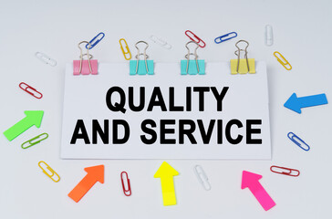 On the table there are paper clips and directional arrows, a sign that says - Quality and Service