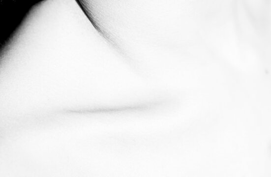 Black and white from above of chest with collarbone of crop unrecognizable person with pure tender skin