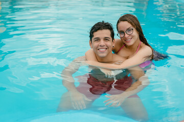 couple swimming in the pool on a sunny day, couple is on vacation swimming in the pool