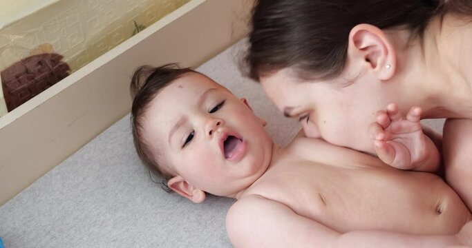 Caring mother and baby are playing in the morning. Concept of baby, parenthood, childhood, maternity, motherhood