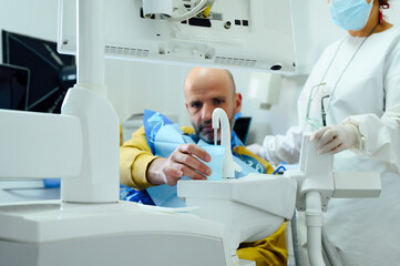 Crop unrecognizable female dentist in uniform and sterile mask against man pouring water from tap into glass after oral operation