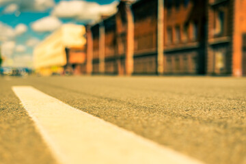Obraz premium Summer in the city, the empty street with the building of red brick. Close up view from the level of the dividing line