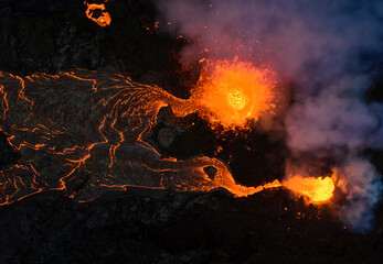 From above magma sparks out of the volcano hole and run like rivers of lava over the ground in Iceland