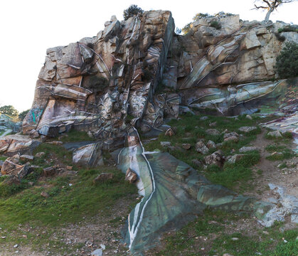 Creative element of graffiti of bird on rough rocky cliff in mountainous terrain