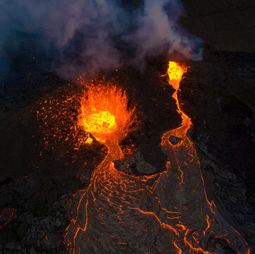 From above magma sparks out of the volcano hole and run like rivers of lava over the ground in Iceland