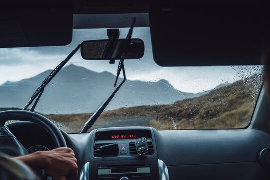 Crop anonymous male driving vehicle on route in majestic Pyrenees mountains during rain