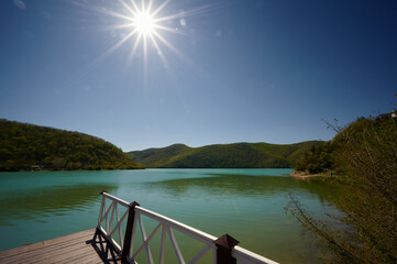 pier in the afternoon against the backdrop of the lake and green hills