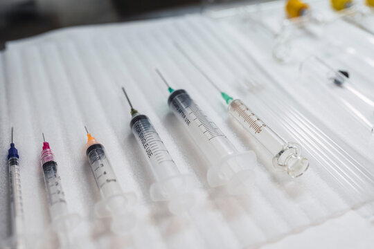 Composition of sterile medical syringes of different sizes arranged on table in hospital