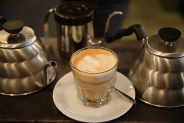 Fresh made latte in coffee shop with coffee making tools arround.