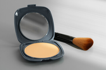 Open box with make up face powder on gray background
