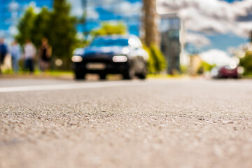 In the downtown, the car passing by on the street. Close up view from the asphalt level
