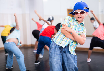 Portrait of confident tween boy hip hop dancer posing during group dance class ..