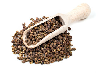 wooden scoop on pile of sichuan pepper on white