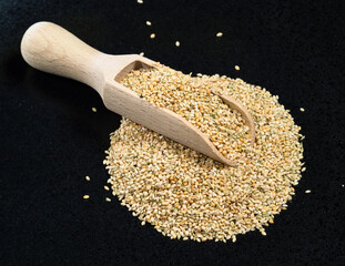 scoop on unhulled foxtail millet seeds on black