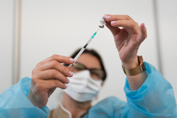 The doctor fills the syringe with the vaccine