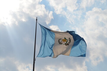 Bandera de Guatemala ondeando en el cielo cubierto de nubes a la luz del día