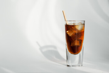 Glass of cola with ice and straw on a white background