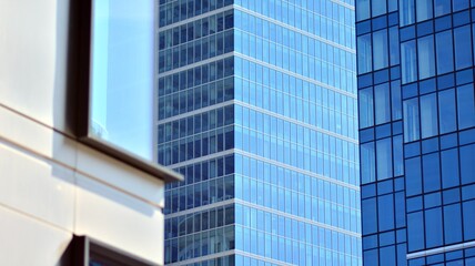 Obraz premium Modern architecture with sun ray. Glass and steel facade on a bright sunny day with sunbeams on the blue sky. Economy, finances, business activity concept.