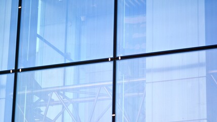 Modern architecture with sun ray. Glass and steel facade on a bright sunny day with sunbeams on the blue sky. Economy, finances, business activity concept.