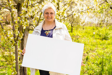 elderly woman holds a photo canvas