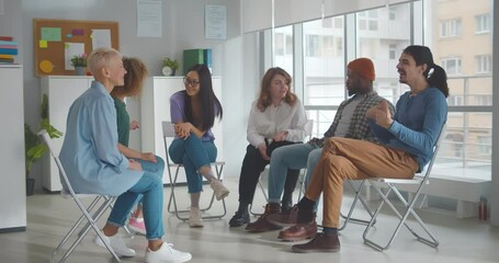 Diverse people talking and helping each other in therapy session or support group meeting