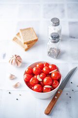 Pickled tomatoes in a bowl with garlic