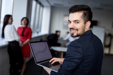 Young smiling businessman, the laptop in the hands of a businessman. 