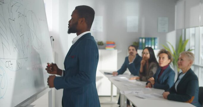 Afro-american businessman giving presentation using white board and smiling at camera