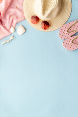 Straw beach womans hat with sun glasses on sand. Top view