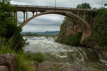 River water flowing under a bridge.