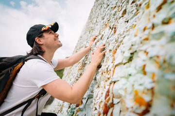 Smiling man climbing a rock wall
