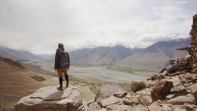 A man looking at the Panj river from Yamchun fortress in Wakhan valley, Tajikistan