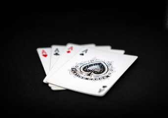 Deck of poker cards with colored chips. 4 aces from the deck with black background