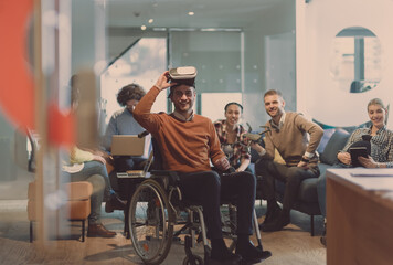 Disabled businessman in a wheelchair at work in modern open space coworking office with team using virtual reality googles drone assistance simulation