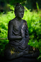 Fototapeta na wymiar Stone statue of a meditating Indian man.