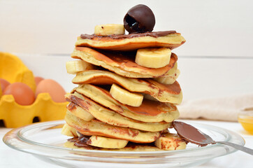 pancakes with chocolate and bananas on a plate close-up