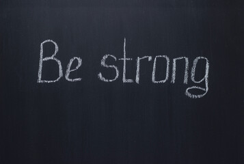 Obraz premium Lettering on dark chalk school blackboard Be strong. Motivational lettering