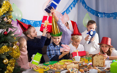 happy american children presenting gifts during Christmas dinner