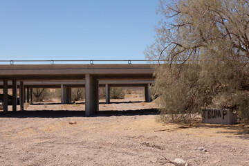 Fototapeta na wymiar Dry wadi passing under a railway bridge in the arid Mojave Desert