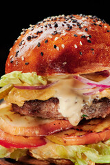 Beef burger with cheese, grill vegetables, tomatoes, red onions and lettuce Close up. Unhealthy food. High quality photo