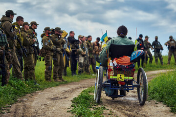 A disabled man in a wheelchair against the background of a group of soldiers