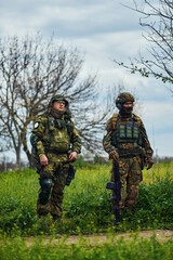 Two soldiers in outfit with weapons in the field