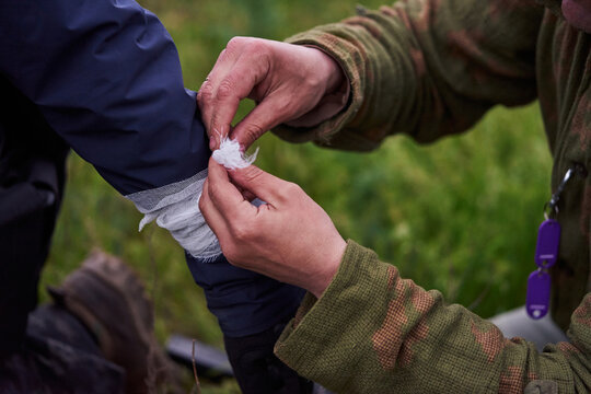 Hands of a soldier bandaging a wounded soldier's hand
