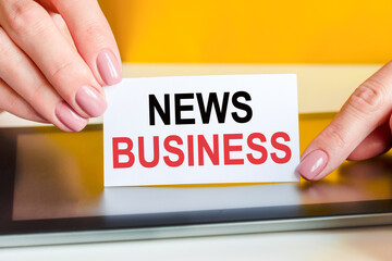 woman holds a piece of paper with the text news business, concept