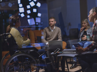 Businesswoman in wheelchair having business meeting with team at modern office 