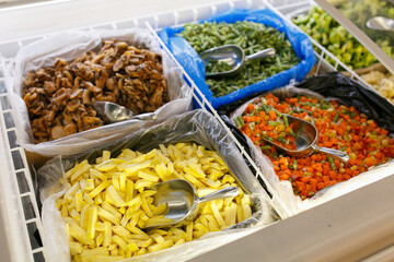 Frozen vegetables in the refrigerator of the store.